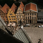 Luftansicht des EMR von der Marienkirche aus gesehen Blick auf den Platz mit farbenfrohen Giebelhäusern und Cafétischen aus der Höhe der Marienkirche.