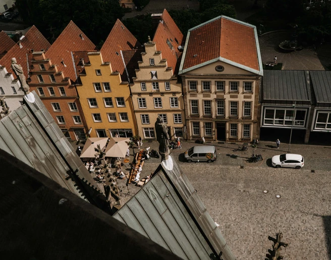 Luftansicht des EMR von der Marienkirche aus gesehen Blick auf den Platz mit farbenfrohen Giebelhäusern und Cafétischen aus der Höhe der Marienkirche.