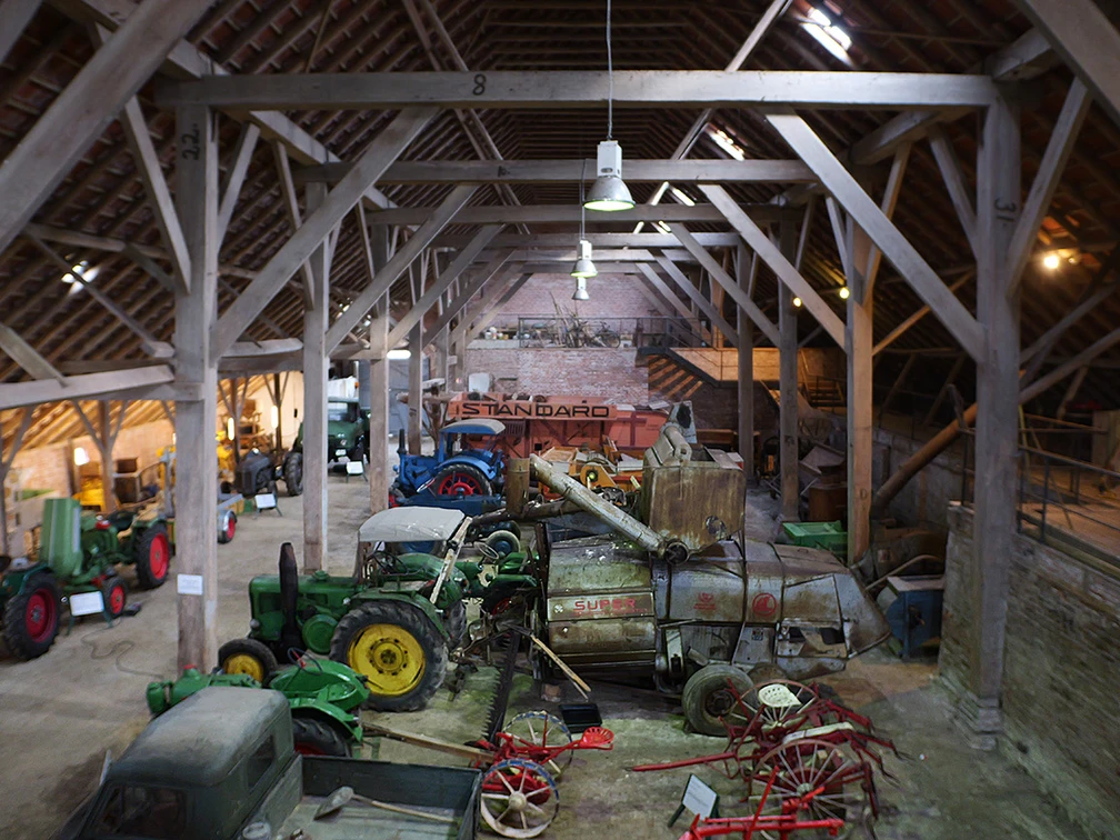 Ostfriesisches Landwirtschaftsmuseum Campen Blick in die Scheune des Museums mit den historischen Treckern und Fahrzeugen.