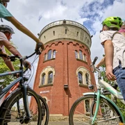 Camera Obscura, Mülheim an der Ruhr Eine vierköpfige Familie mit Fahrrädern betrachtet den Broicher Wasserturm mit der Camera Obscura bei einer Fahrradtour.