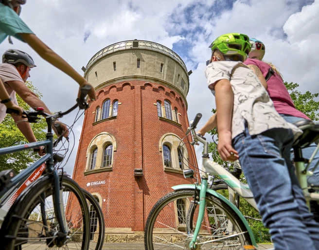 Camera Obscura, Mülheim an der Ruhr Eine vierköpfige Familie mit Fahrrädern betrachtet den Broicher Wasserturm mit der Camera Obscura bei einer Fahrradtour.