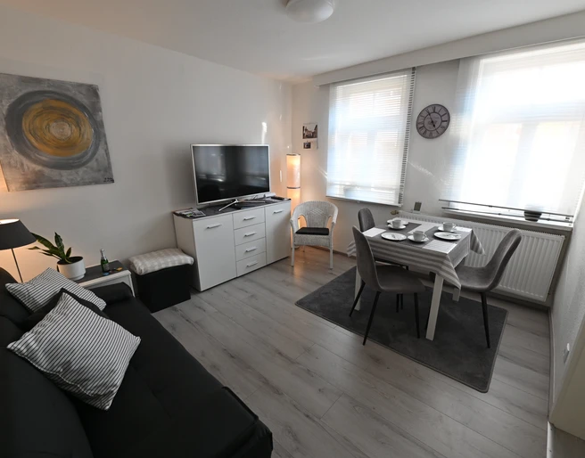 ferienhaeuschen_an_der_stadtmauer_essbereich.jpg Wohnbereich mit Essplatz, Sofa und FernseherLiving area with dining area, sofa and TV