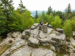 Lippischer Velmerstot-Kreis Lippe-Teutoburger-Wald-Tourismus-D-Ketz-026.jpg Zwei Wanderer bei einer Pause auf einem Felsenplateau mit Aussicht inmitten eines bewaldeten Gebiets.