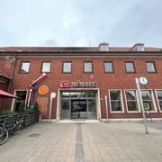 Bahnhof Nienburg Zweistöckiges Backsteingebäude des Bahnhofs Nienburg mit stilvollem DB-Schild über dem Eingang.