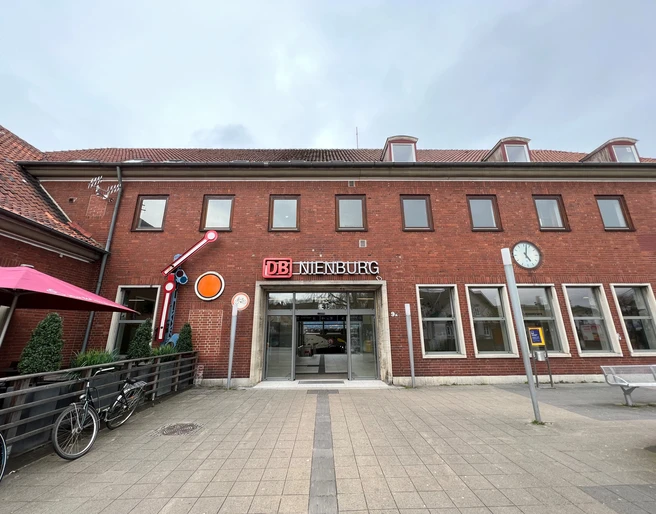 Bahnhof Nienburg Zweistöckiges Backsteingebäude des Bahnhofs Nienburg mit stilvollem DB-Schild über dem Eingang.