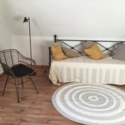 fewo_erdmann_daybed.jpeg Stuhl neben Tagesbett im Wohnzimmer