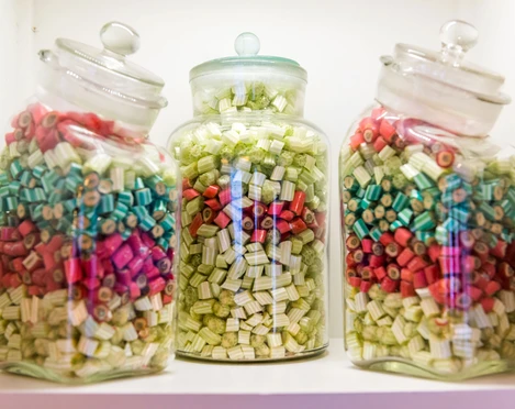 Dosen voller Bonbons Drei Glasbehälter mit bunten Bonbons in Rot, Grün und Blau auf einem Regal; die Atmosphäre wirkt nostalgisch und einladend.