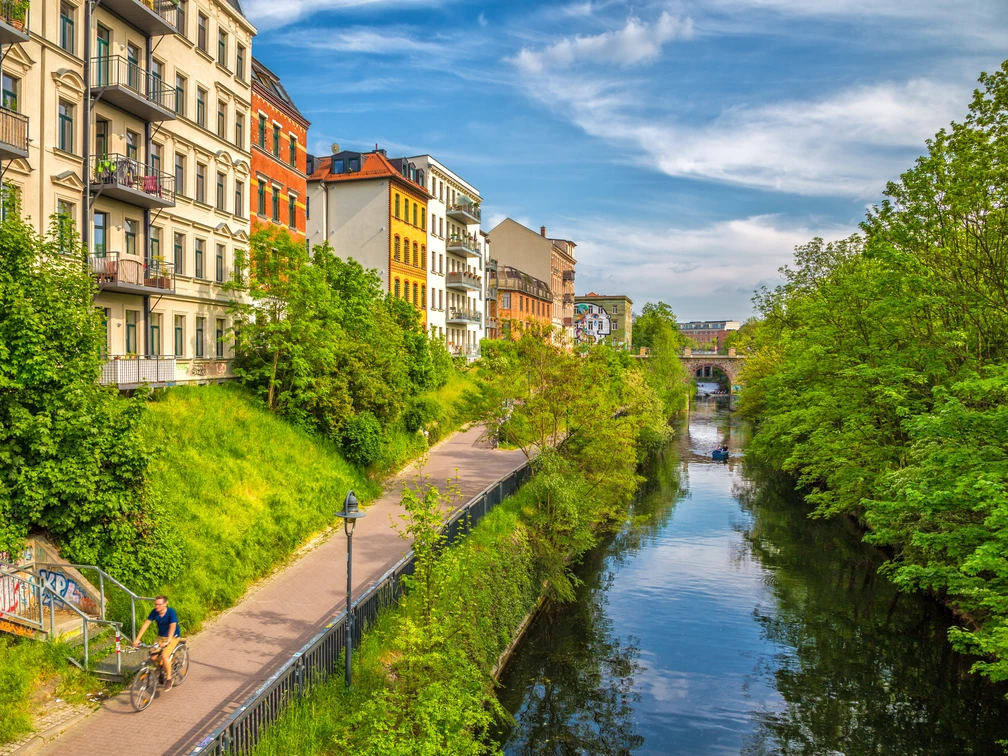 Karl-Heine-Kanal in der Wasserstadt - Fahrrad und Kanufahren in Leipzig Grünende Bäume am Karl-Heine-Kanal im Sommer, bunte Häuser, blauer Himmel, Wasser