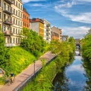 Karl-Heine-Kanal in der Wasserstadt - Fahrrad und Kanufahren in Leipzig Grünende Bäume am Karl-Heine-Kanal im Sommer, bunte Häuser, blauer Himmel, Wasser