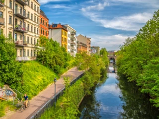 Karl-Heine-Kanal in der Wasserstadt - Fahrrad und Kanufahren in Leipzig Grünende Bäume am Karl-Heine-Kanal im Sommer, bunte Häuser, blauer Himmel, Wasser