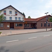 Hotel mit Backsteinfassade und traditionellen Schriftzügen, gelegen an einer ruhigen Straße.