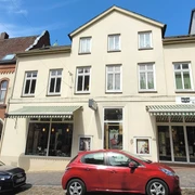 Buchhandlung Weber_Silvana Dust_20230510 (4).jpg Die Vorderseite der Buchhandlung Weber. Ein helles Gebäude mit Parkmöglichkeiten davor