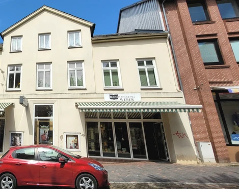 Buchhandlung Weber_Silvana Dust_20230510 (4).jpg Die Vorderseite der Buchhandlung Weber. Ein helles Gebäude mit Parkmöglichkeiten davor