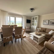 haus_ella_wohnzimmer2.jpg Wohnzimmer mit Sofa und Esstisch eingerichtet im Landhausstil