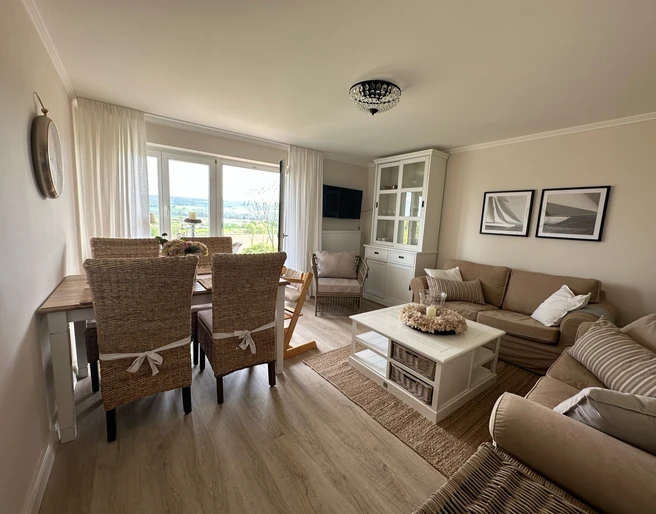 haus_ella_wohnzimmer2.jpg Wohnzimmer mit Sofa und Esstisch eingerichtet im Landhausstil