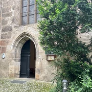Klosterkirche St. Heinrich Pirna Eingang zur Klosterkirche St. Heinrich in Pirna mit gotischem Bogen und umgebender Natur.