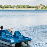 Tretbootausleih am Kulkwitzer See im Leipziger Neuseenland Am Ufer des Kulkwitzer Sees liegen blaue Tretboote vor Anker, bereit für ausgedehnte Seefahrten.