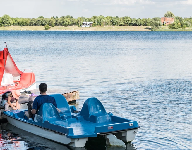 Tretbootausleih am Kulkwitzer See im Leipziger Neuseenland Am Ufer des Kulkwitzer Sees liegen blaue Tretboote vor Anker, bereit für ausgedehnte Seefahrten.