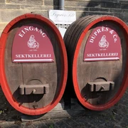Sektkellerei Duprès Zwei große Holzfässer mit roten Schildern kennzeichnen den Eingang der Sektkellerei Duprès.