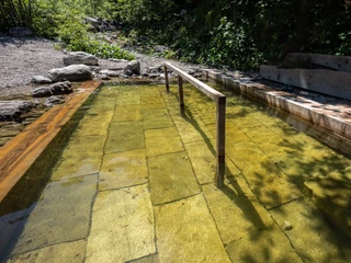 Kneippbecken Farchant Wasserbecken mit Stange zum Einhalten im Hintergrund Büsche