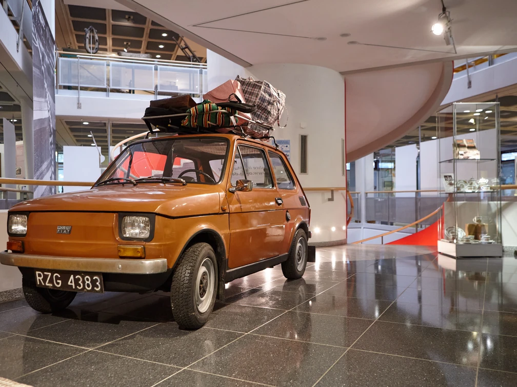 Oberschlesisches Landesmuseum in Ratingen Ein orangefarbenes Auto mit Dachgepäckträger steht im modernen Foyer des Oberschlesischen Landesmuseums.