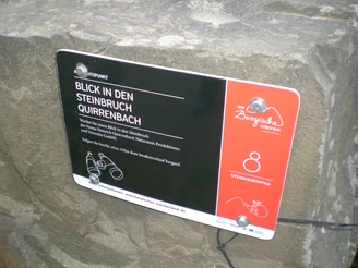 Tafel am Aussichtspunkt Hinweisschild des Steinbruchs Quirrenbach in Lindlar, samt Wegbeschreibung im Bergischen Wanderland.