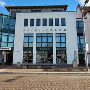 Petri Forum_1980x1080_Silvana Dust_20230510 (1).jpg Ein Gebäude in der Innenstadt hat eine weiße Fassade und die Aufschrift ‚Petri Forum
