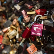 Love locks Bunte Vorhängeschlösser mit Gravuren zieren ein Gitter, symbolisieren Liebe und Verbundenheit.Colorful padlocks with engravings adorn a lattice, symbolizing love and solidarity.