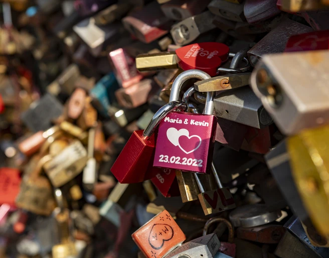 Love locks Bunte Vorhängeschlösser mit Gravuren zieren ein Gitter, symbolisieren Liebe und Verbundenheit.Colorful padlocks with engravings adorn a lattice, symbolizing love and solidarity.