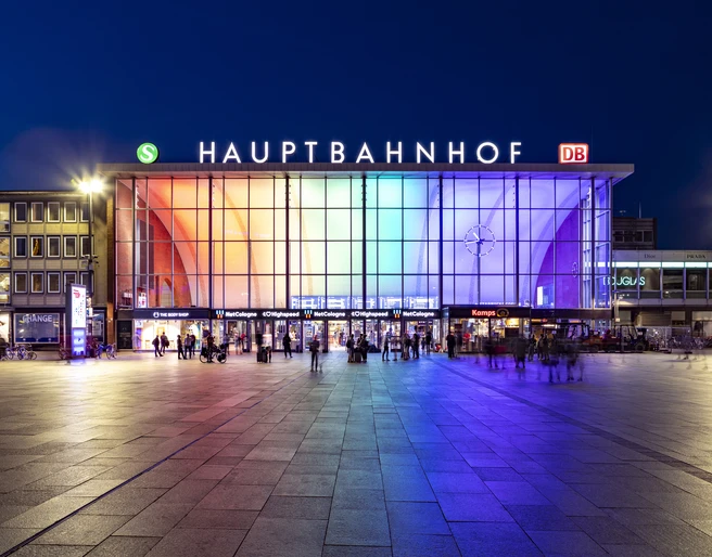 Köln Hauptbahnhof Der Eingang des Kölner Hauptbahnhofs bei Nacht, beleuchtet in Regenbogenfarben.The entrance to Cologne Central Station at night, illuminated in rainbow colors.