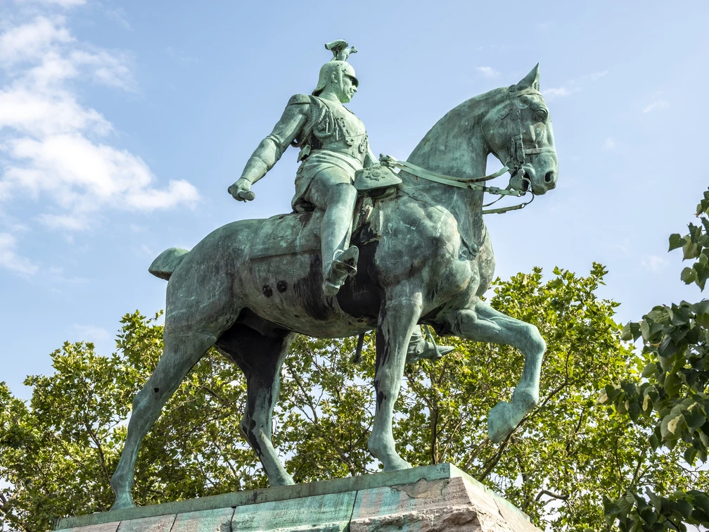 Equestrian statue of King Frederick William III. Das Bild zeigt das beeindruckende Reiterstandbild von Kaiser Wilhelm II. in Köln. Kaiser Wilhelm sitzt majestätisch auf einem kräftigen Pferd, umgeben von grünen Bäumen und einem klaren, blauen Himmel im Hintergrund. The picture shows the impressive equestrian statue of Kaiser Wilhelm II in Cologne. Kaiser Wilhelm sits majestically on a powerful horse, surrounded by green trees and a clear blue sky in the background.