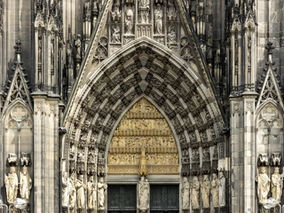 Cologne Cathedral Detailreiche gotische Fassade des Kölner Doms mit kunstvoll verzierten Statuen und steinerner Ornamente.Detailed Gothic façade of Cologne Cathedral with elaborately decorated statues and stone ornaments.
