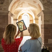 weibliches Pärchen betrachtet auf Tablet die früheren kunstvollen Verzierungen im JohanneschorFemale couple looking at the former ornate decorations in St. John's Choir on a tablet