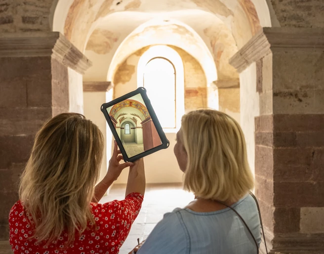 Hoexter-Augmented Reality in Johanneschor-Stadt Hoexter-D. Ketz-2023-462.jpg weibliches Pärchen betrachtet auf Tablet die früheren kunstvollen Verzierungen im JohanneschorFemale couple looking at the former ornate decorations in St. John's Choir on a tablet