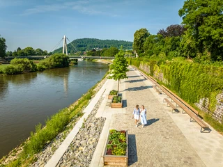 Hoexter-Weserufer-Stadt Hoexter-D. Ketz-2023-270.jpg Frauen spazieren auf Weserpromenade mit Brücke im HintergrundWomen walking on the Weser promenade with a bridge in the background