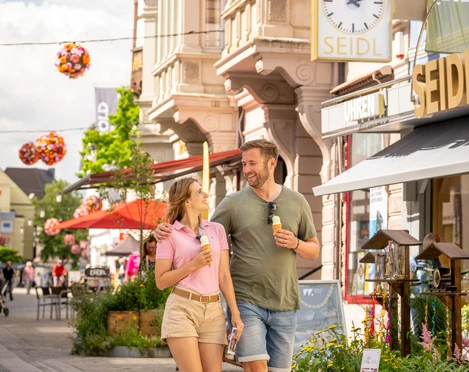 Hoexter-Stadtrundgang-Stadt Hoexter-D. Ketz-2023-086.jpg Pärchen genießt mit Blumen geschmückte Fußgängerzone in HöxterCouple enjoys pedestrian zone decorated with flowers in Höxter
