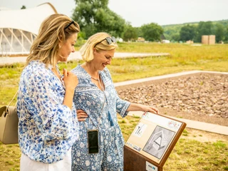 Hoexter-Landesgartenschaugelände Archeologiepark-Stadt Hoexter-D. Ketz-2023-355.jpg Zwei Frauen vor Informationstafel in Archäologiepark