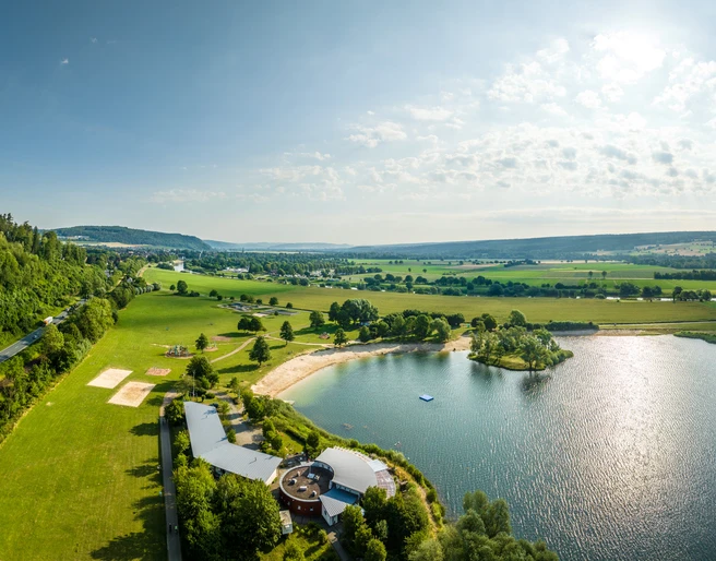 Hoexter-Freizeitanlage Godelheimer See-Stadt Hoexter-D. Ketz-2023-228.jpg Luftaufnahme des Badesees der Freizeitanlage Höxter-Godelheim mit Sandstrand und Sanitärgebäuden