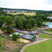 KN7A0233.jpg Luftaufnahme eines Freizeitparks mit Wasserrutschen, Spielplätzen, umgeben von Wald und See.