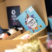 Office de tourisme de Leipzig – Produits régionaux originaires de Leipzig Foto einer Geschenkekiste der Leipziger Manufaktur "Kern und Stein", die im Souvenirbereich der Tourist-Information Leipzig steht, Regionale ProdukteFotografia skrzyni prezentów lipskiej manufaktury „Kern und Stein”, która stoi w strefie pamiątek Informacji Turystycznej w Lipsku, produkty regionalnePhoto of a gift box containing hand-made products from the Leipzig artisan company "Kern und Stein" in the souvenir department at Leipzig Tourist Information Office, local products.Photo d'un coffret cadeau de l’atelier « Kern und Stein » de Leipzig, dans la boutique de souvenirs de l'office de tourisme de Leipzig, Produits régionauxFotografie dárkové skříňky od lipské manufaktury „Kern und Stein", kterou najdete v koutku se suvenýry v lipském turistickém informačním centrum, regionální produkty