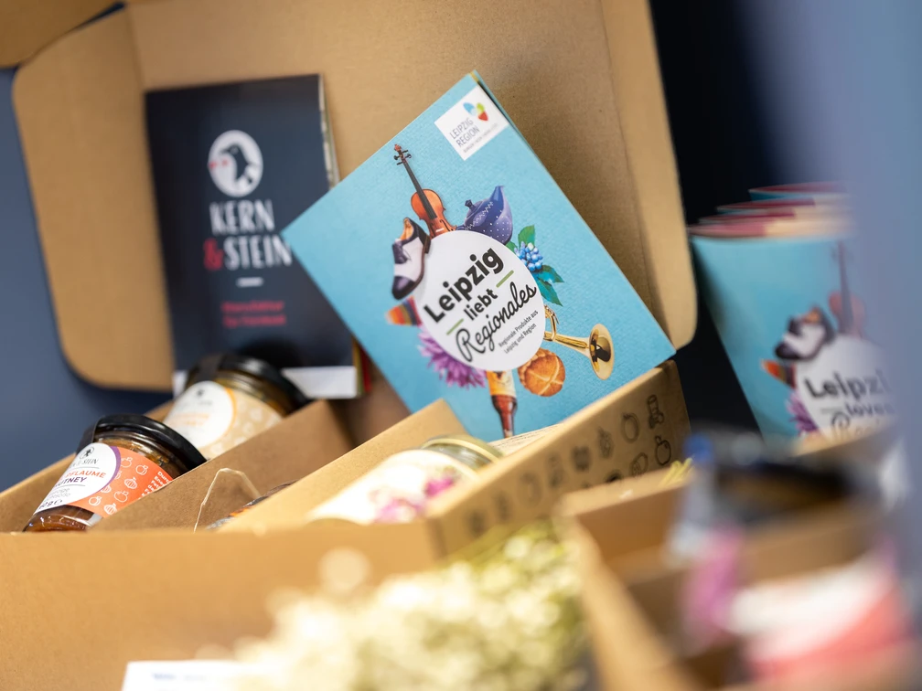 Tourist-Information Leipzig - Regionale Produkte aus Leipzig Foto einer Geschenkekiste der Leipziger Manufaktur "Kern und Stein", die im Souvenirbereich der Tourist-Information Leipzig steht, Regionale ProdukteFotografia skrzyni prezentów lipskiej manufaktury „Kern und Stein”, która stoi w strefie pamiątek Informacji Turystycznej w Lipsku, produkty regionalnePhoto of a gift box containing hand-made products from the Leipzig artisan company "Kern und Stein" in the souvenir department at Leipzig Tourist Information Office, local products.Photo d'un coffret cadeau de l’atelier « Kern und Stein » de Leipzig, dans la boutique de souvenirs de l'office de tourisme de Leipzig, Produits régionauxFotografie dárkové skříňky od lipské manufaktury „Kern und Stein", kterou najdete v koutku se suvenýry v lipském turistickém informačním centrum, regionální produkty