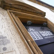 Eingang zur Probebühne Osnabrück, ein Amateur-Theater, mit historischem Kirchenportal und Infotafel.