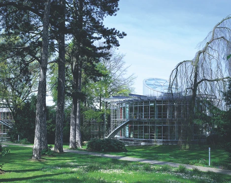 Die Deutsche Bundesstiftung Umwelt in Osnabrück Moderne Glasarchitektur der Deutschen Bundesstiftung Umwelt, umgeben von hohen Bäumen und Grünflächen.