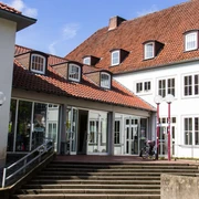 Das Haus der Jugend Osnabrück Eingang zum Haus der Jugend in Osnabrück mit rotem Ziegeldach und großen Fenstern im Tageslicht.