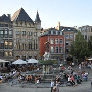 Belebter Marktplatz mit historischen Gebäuden und dem Karlsbrunnen im Zentrum.