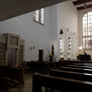 Klosterkirche der Aacherner Franziskanerinnen Innenansicht der Klosterkirche mit schlichter Einrichtung, Kirchenbänken und bunten Glasfenstern.