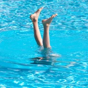 Zwei Füße schauen aus einem Schwimmbecken heraus.