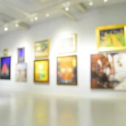 Unscharfe Kunstwerke in einem beleuchteten Galerie-Raum.