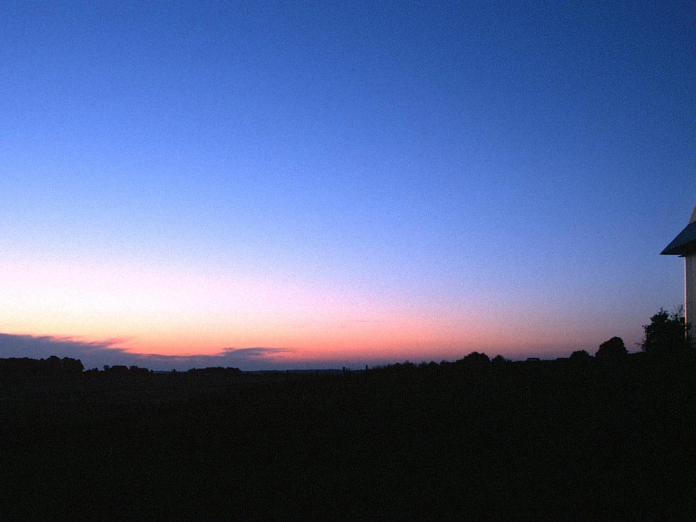 EXPO-Sternwarte Einsame Mühle im Abendlicht vor einem eindrucksvollen Sonnenuntergangshimmel.