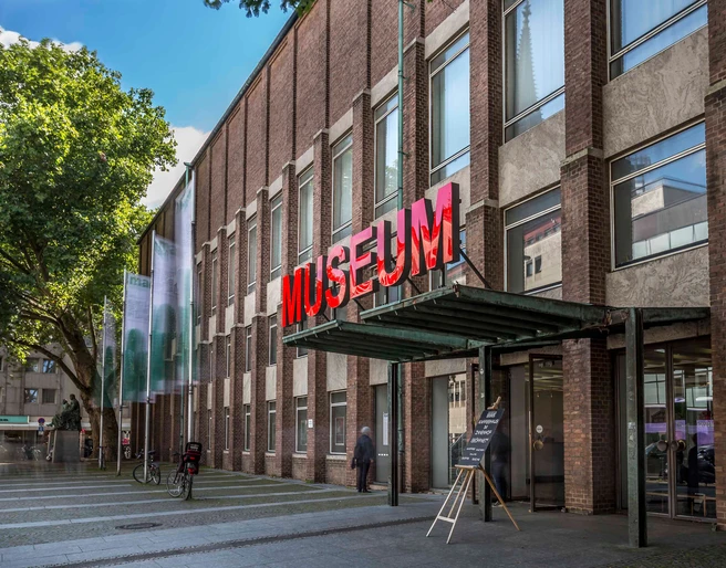 Museum of Applied Arts Cologne Das Bild zeigt die Fassade des Museums für Angewandte Kunst Köln mit auffälliger roter Neonschrift.The picture shows the façade of the Museum of Applied Arts Cologne with striking red neon lettering.